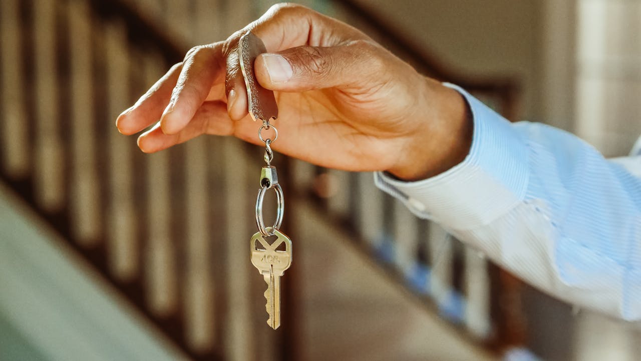 services-01 A close-up shot of a hand holding a house key, indicating new ownership or rental.